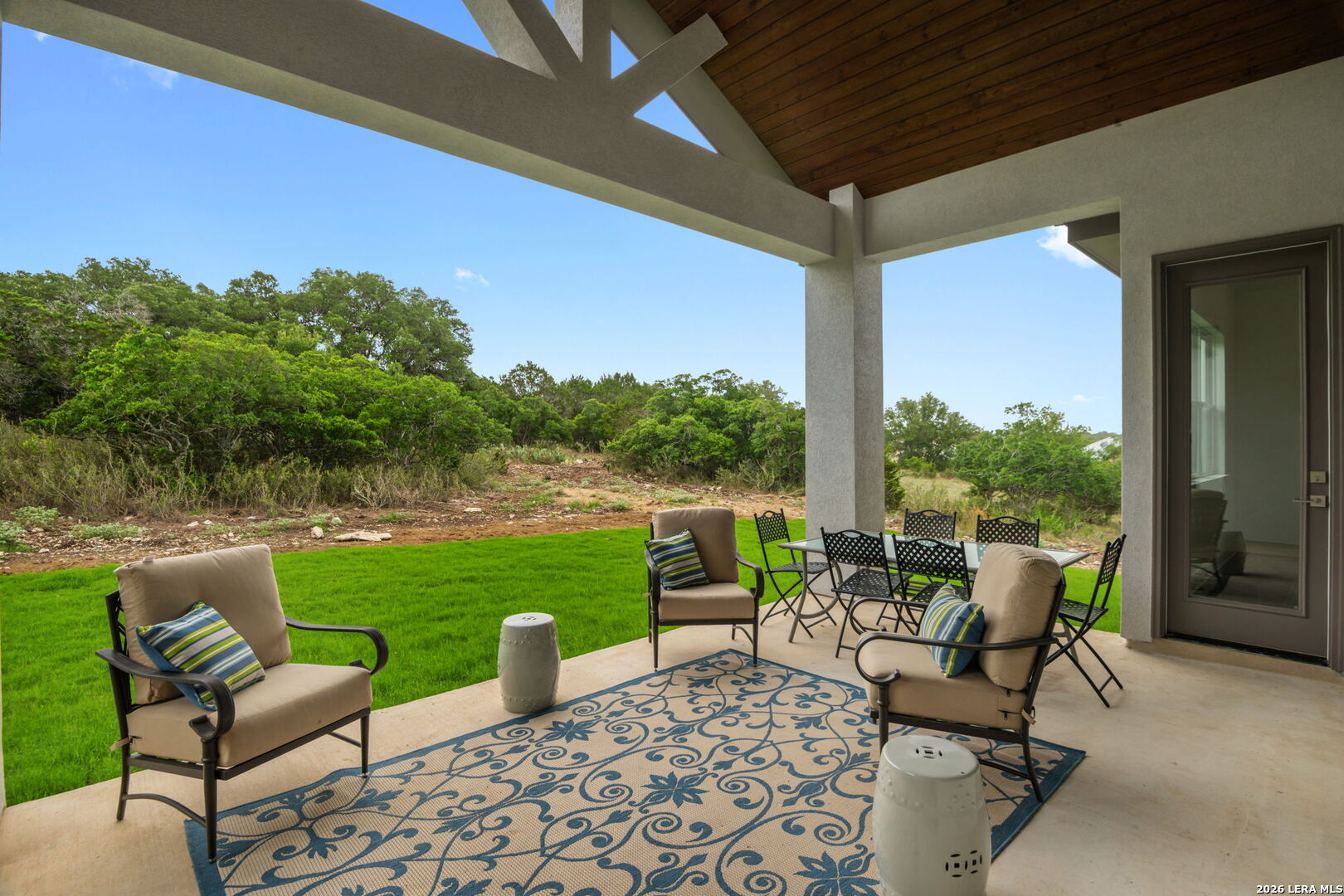 1465 Ironwood Road Fischer, TX 78623 - Photo 30 of 38 a view of a patio with chairs and floor to ceiling window