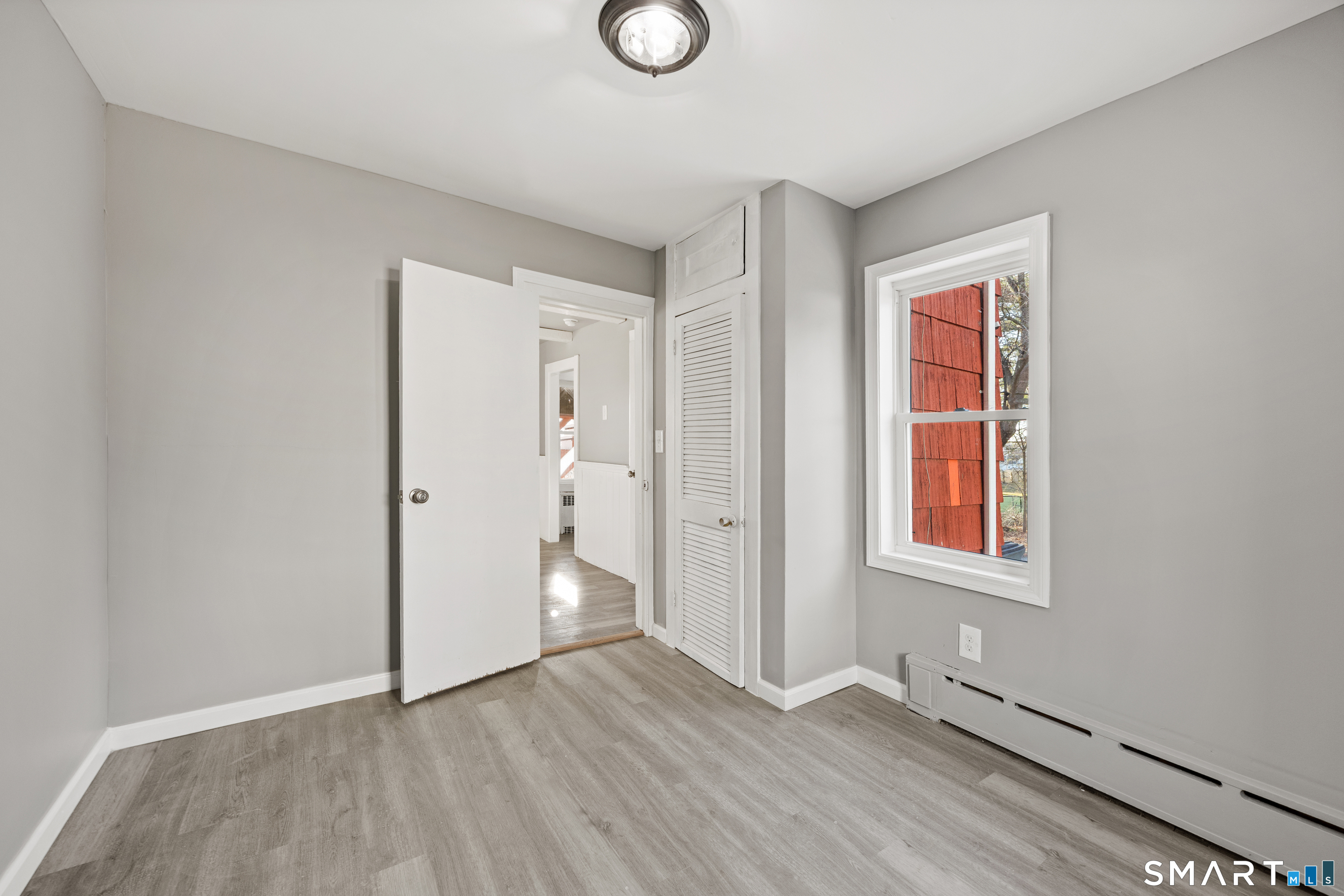 153 Funston Avenue, Unit 1 Torrington, CT 06790 - Photo 11 of 16 an empty room with wooden floor and window