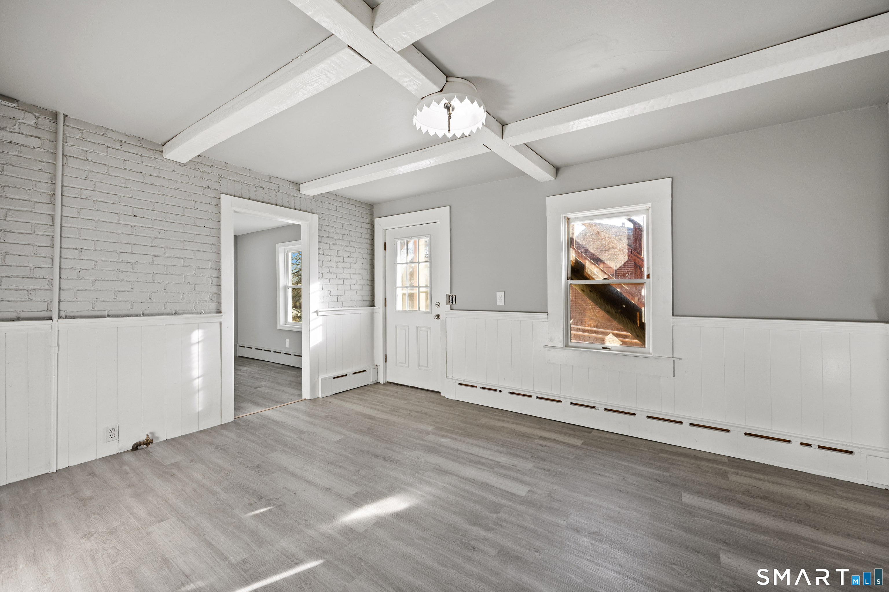 153 Funston Avenue, Unit 1 Torrington, CT 06790 - Photo 12 of 16 an empty room with wooden floor chandelier and windows