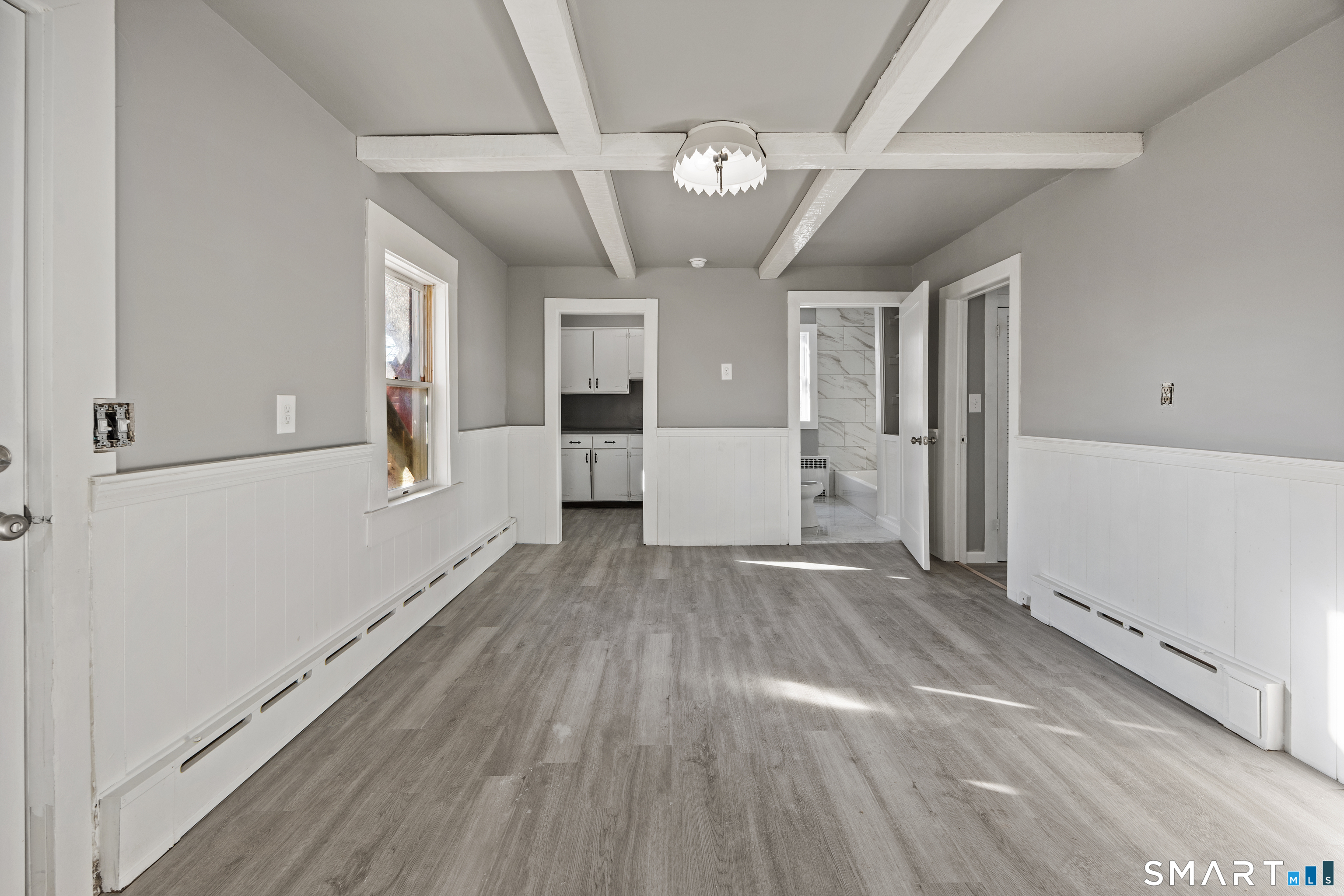 153 Funston Avenue, Unit 1 Torrington, CT 06790 - Photo 3 of 16 a view of a big room with wooden floor and windows