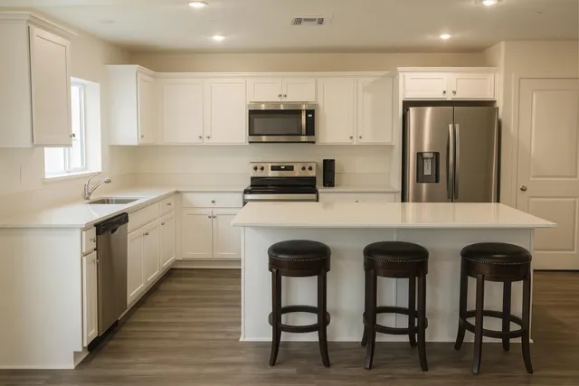 a kitchen with granite countertop a table chairs microwave and refrigerator