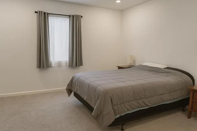 a bed sitting in a bedroom next to a window