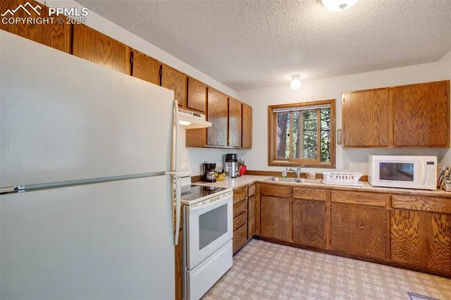 a kitchen with a sink a refrigerator and cabinets