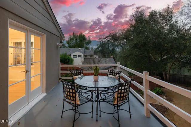 a view of a house with a small yard and large tree