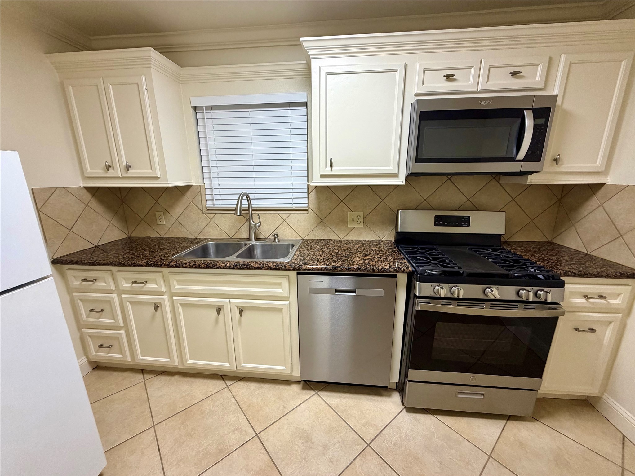 2812 Wichita Street, Unit 6 Houston, TX 77004 - Photo 1 of 15 a kitchen with granite countertop white cabinets stainless steel appliances and a sink