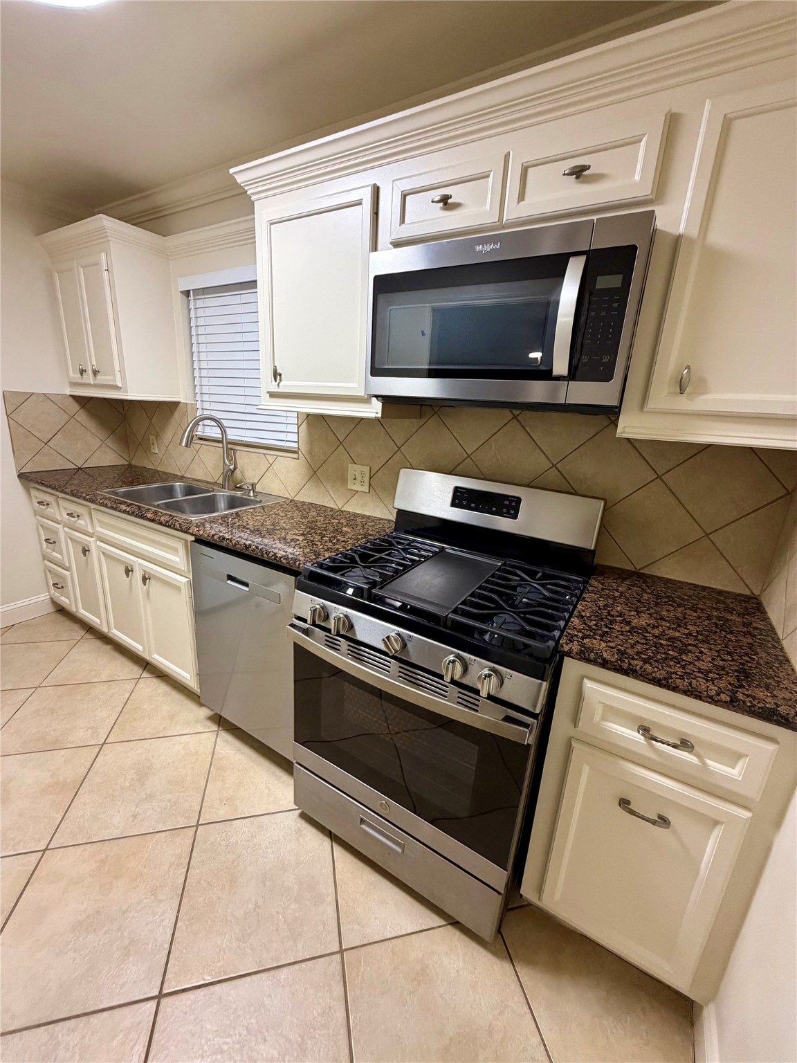 2812 Wichita Street, Unit 6 Houston, TX 77004 - Photo 5 of 15 a kitchen with granite countertop a stove top oven microwave and cabinets