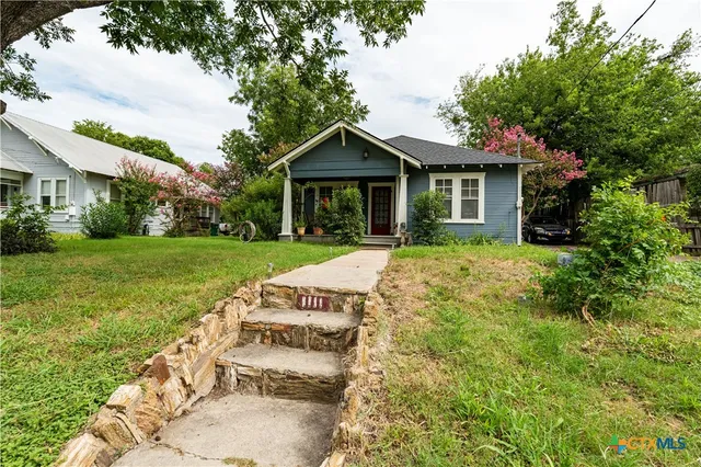 a view of a house with yard and a garden