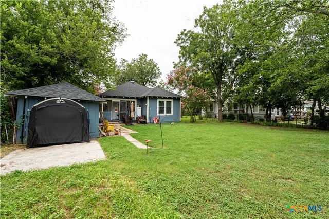 a view of a house with backyard and sitting area