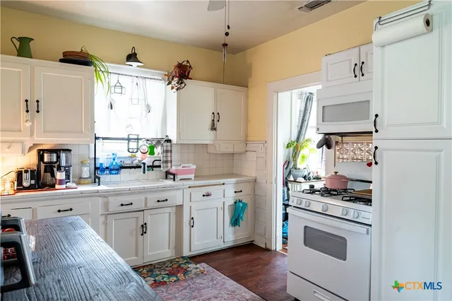 a kitchen with stainless steel appliances a stove refrigerator sink and cabinets