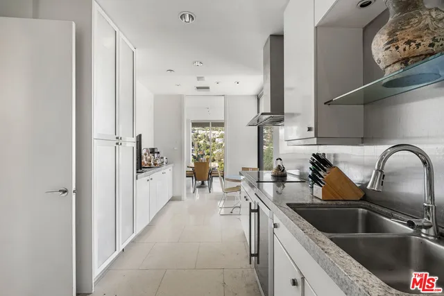 a kitchen with white cabinets and sink