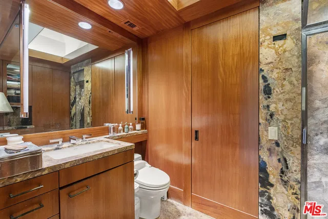 a bathroom with a granite countertop sink toilet and shower