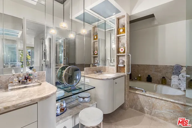 a bathroom with a granite countertop sink mirror vanity and toilet