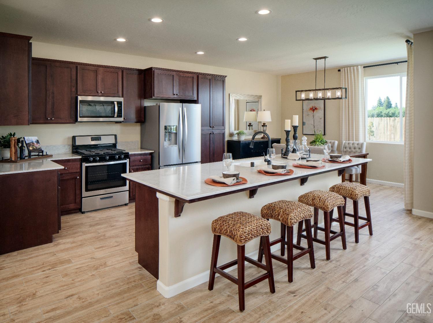 Undisclosed Address Delano, CA 93215 - Photo 6 of 7 a large kitchen with kitchen island a dining table and chairs