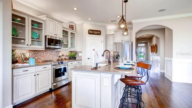 a kitchen with stainless steel appliances a dining table and stove