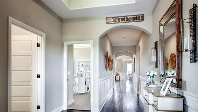 a view of a hallway with wooden floor windows and a livingroom