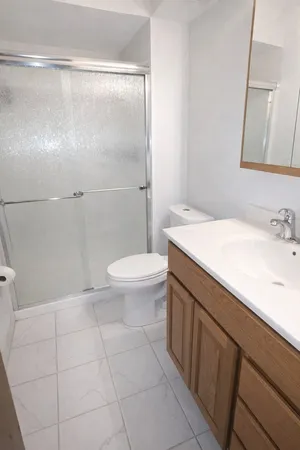 a spacious bedroom with a bed and wooden floor