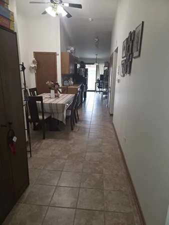 a view of a dining hall with a dining table a chandelier and a rug