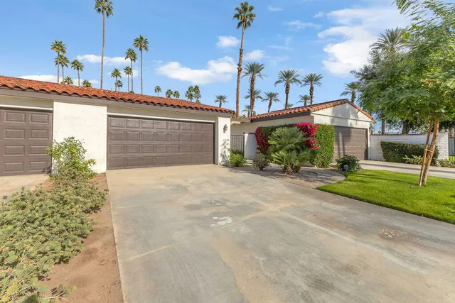 a front view of a house with a yard and potted plants