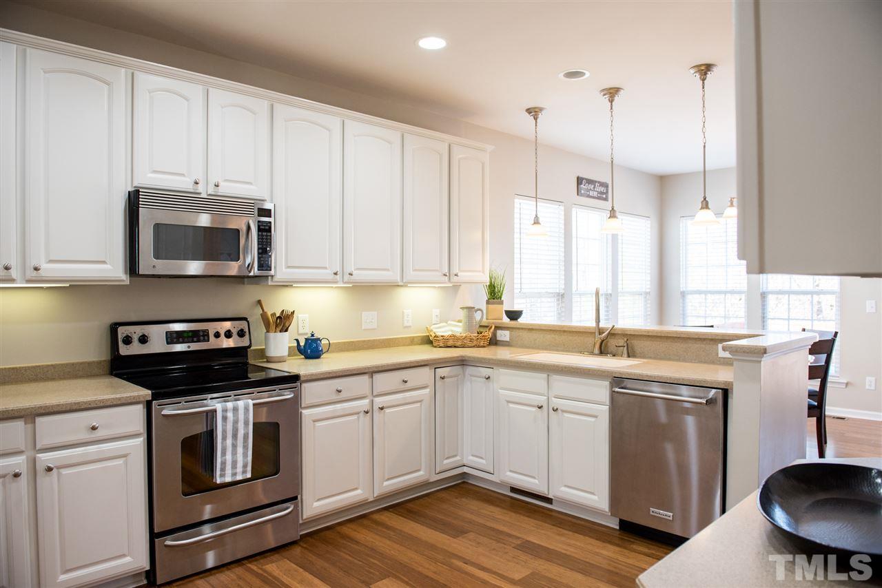 7725 Jackson Dane Drive Raleigh, NC 27613 - Photo 4 of 24 a kitchen with a sink stove and white cabinets