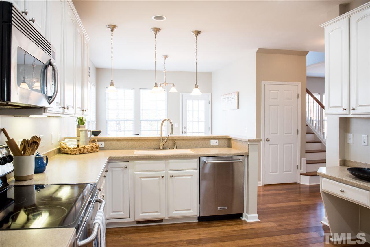 7725 Jackson Dane Drive Raleigh, NC 27613 - Photo 5 of 24 a kitchen with a sink a stove and cabinets