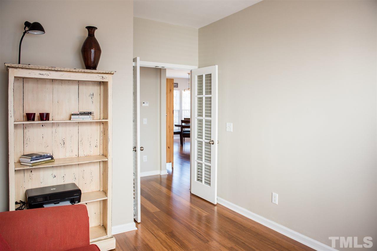 7725 Jackson Dane Drive Raleigh, NC 27613 - Photo 9 of 24 a view of a hallway with wooden floor and cabinets
