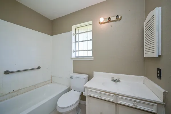 a bathroom with a sink toilet vanity and bathtub