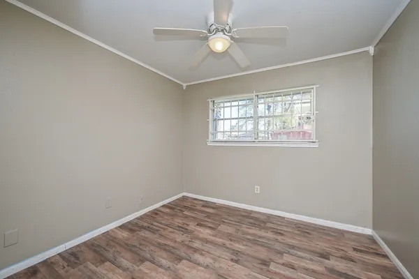 an empty room with a window and ceiling fan