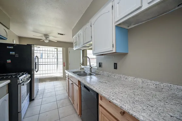 a kitchen with a sink stove and cabinets