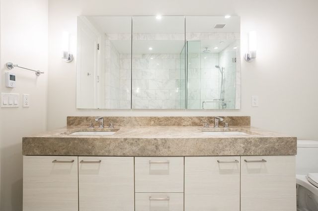a bathroom with a granite countertop sink and a mirror