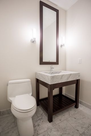 a bathroom with a sink a toilet and mirror