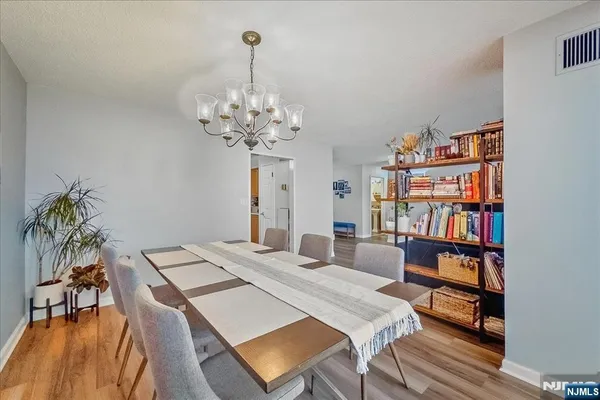 a view of a hallway with wooden floor and a living room