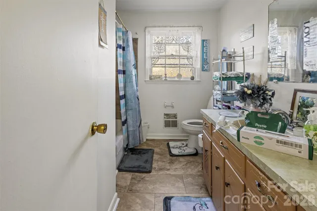 a bathroom with a sink a toilet and a window