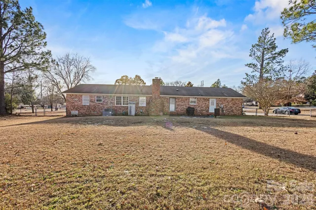 a front view of a house with a yard and trees