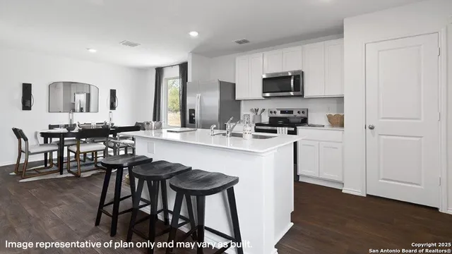 a kitchen with stainless steel appliances a sink a stove a microwave a counter top space and cabinets