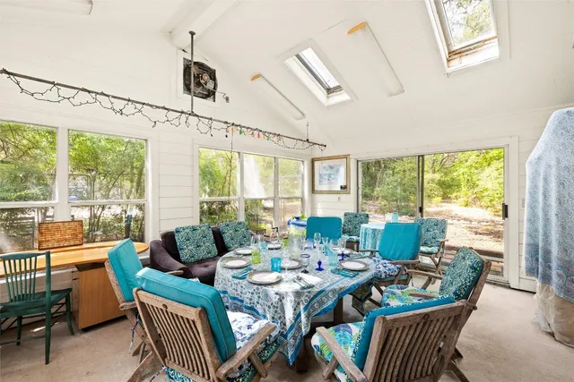 a dining room with furniture a rug and a large window