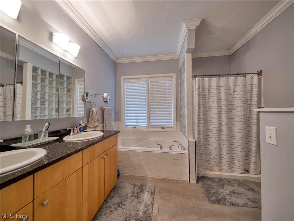 13730 Sperry Road Novelty, OH 44072 - Photo 15 of 31 Bathroom with crown molding, vanity with extensive cabinet space, dual sinks, tile flooring, and shower with separate bathtub
