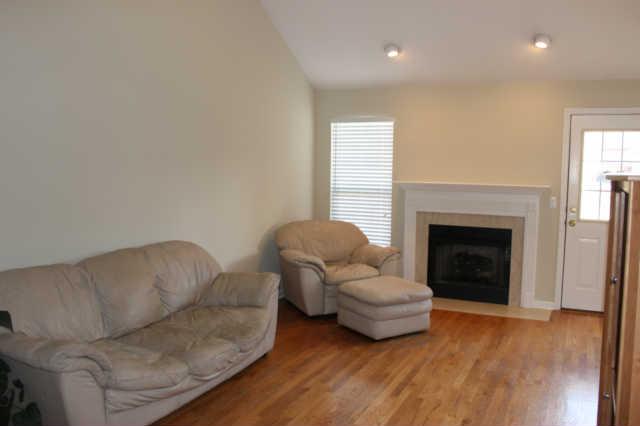 Family room features gas logs in fireplace,  vaulted ceiling and hardwood flooring