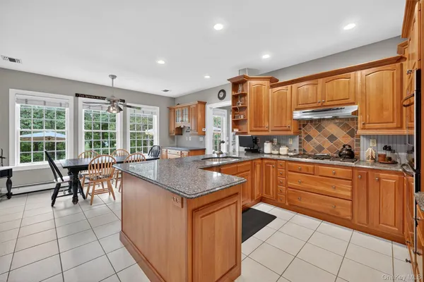 a kitchen with granite countertop sink window and dining table