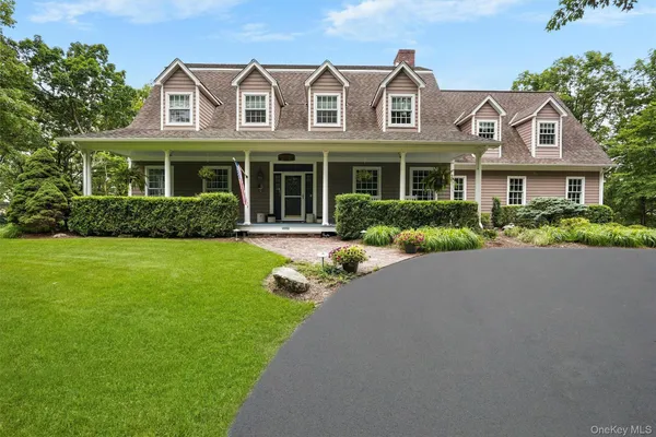 a front view of a house with a yard and potted plants