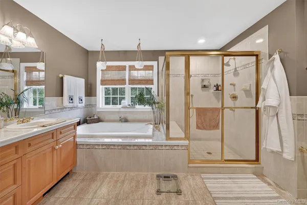 a bathroom with a double vanity sink a mirror and a bathtub