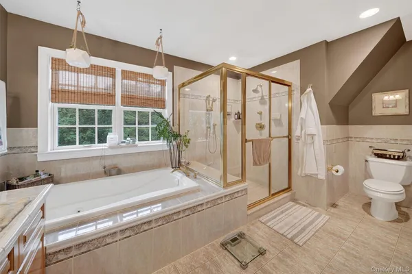 a spacious bathroom with a granite countertop tub a sink and a large window