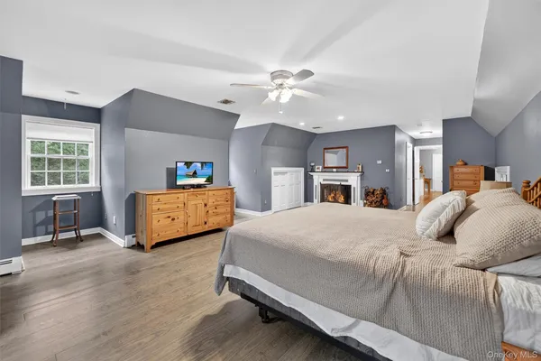 a bedroom with a large bed a flat tv screen and dresser