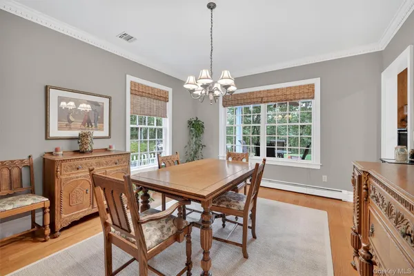 a dining room with furniture a chandelier and window