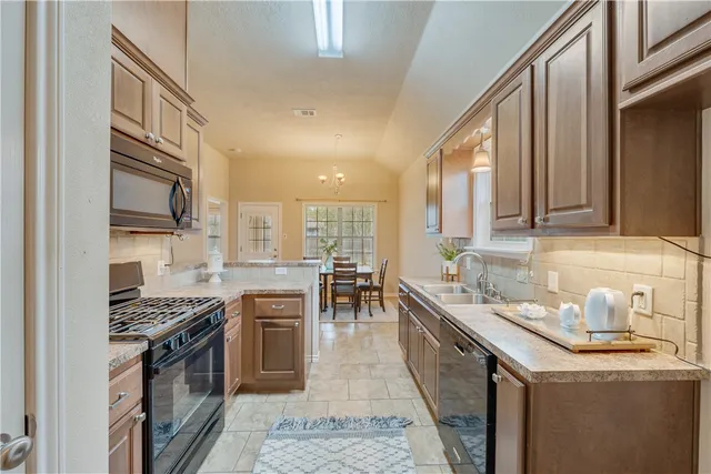 a kitchen with a sink stove top oven and cabinets