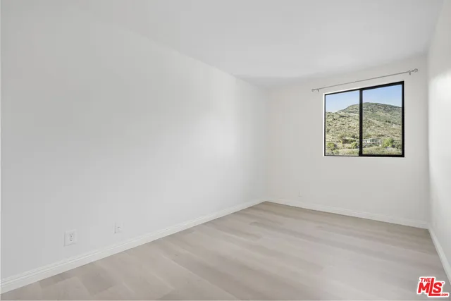 a view of a room with a wooden floor and a window
