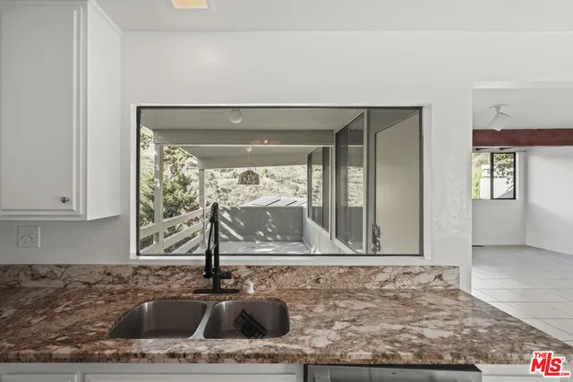 a view of a room with a ceiling fan and window