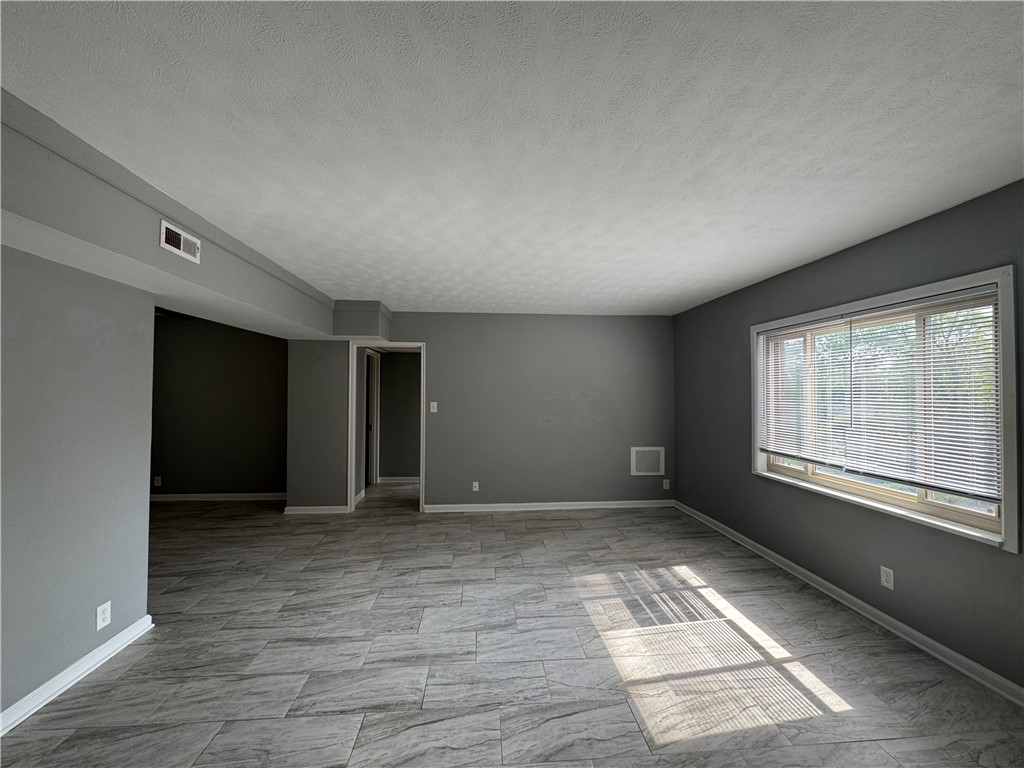 2358 South Patterson Boulevard, Unit 6 Kettering, OH 45409 - Photo 2 of 9 This spacious living area features ample natural light and modern tile flooring, perfect for versatile living.