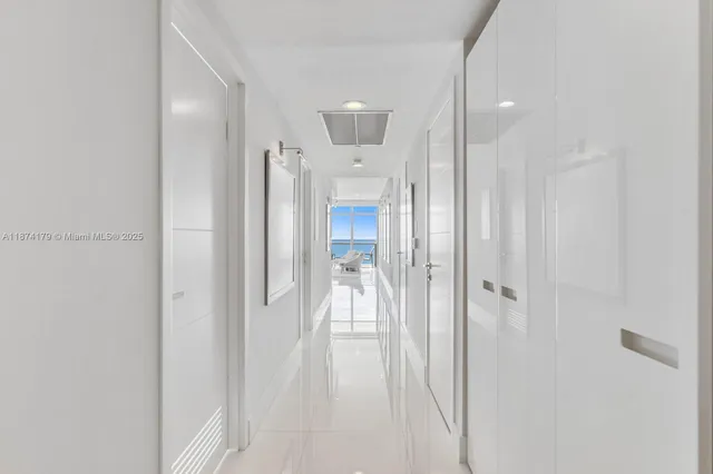 a view of a hallway with a livingroom and a chandelier