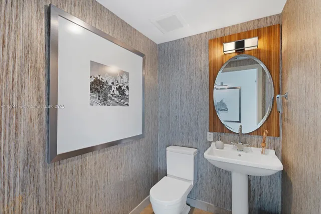 a bathroom with a toilet a sink and mirror