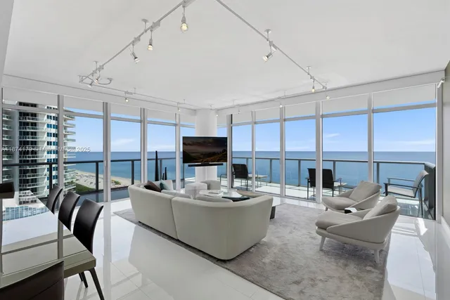 a living room with fireplace furniture and a large window